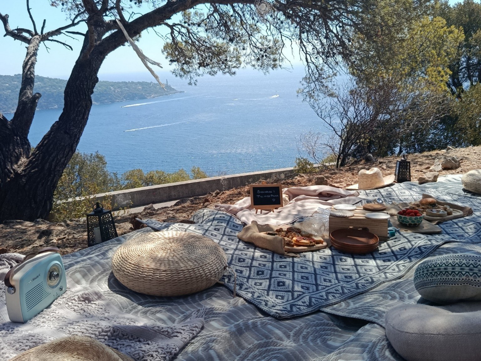 Daytime picnic with woven poufs facing the bay of Saint-Jean-Cap-Ferrat